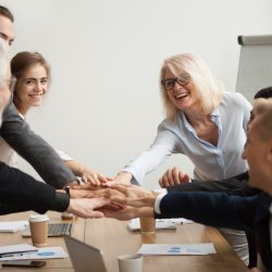 Bigstock  124240972 Happy Smiling Corporate Team Of Senior Executives And Young Employees Join Hands Together At Group M